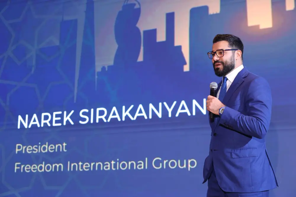 Narek in a blue suit with a microphone