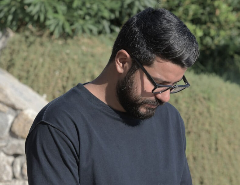 Narek in a gray t-shirt is looking down