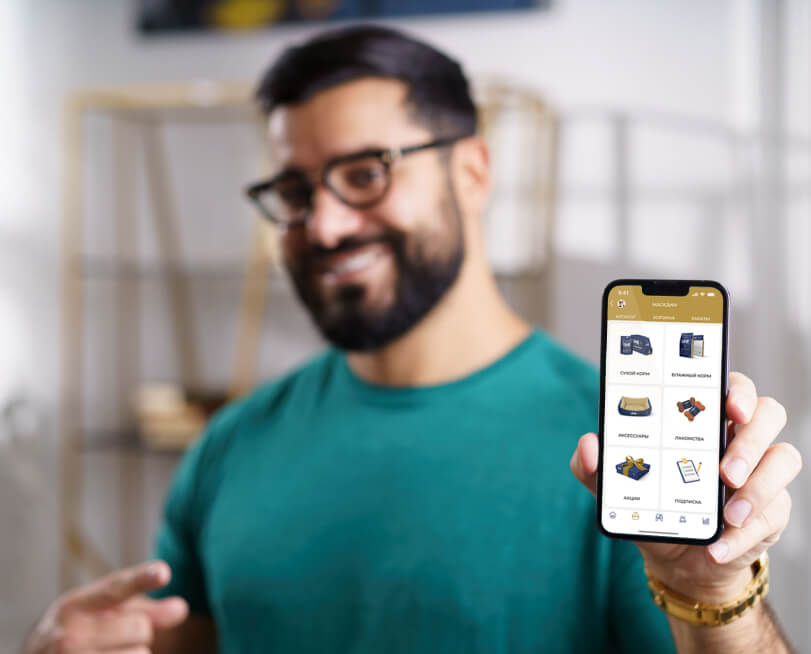 Narek in a teal t-shirt with a phone with UME app