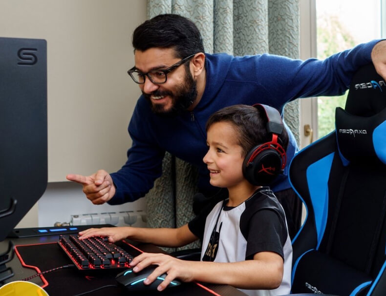 Narek points with his finger and watches his son play