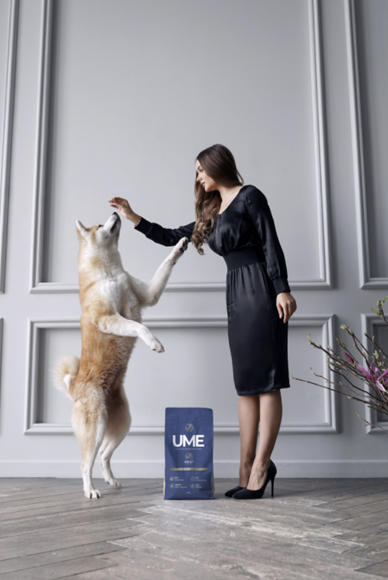 Woman standing with a Shiba Inu dog and UME food